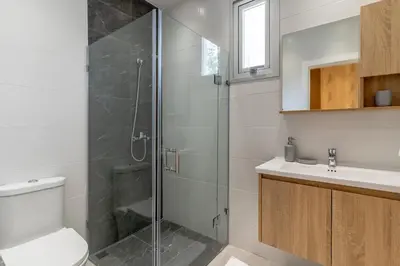 a bathroom with a shower and a toilet and a sink at Elegant Seaside Villa Steps to Beach & Golf Course in Boca del Soco