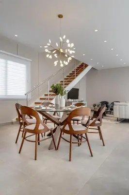a dining room with a table and chairs and a staircase at Elegant Seaside Villa Steps to Beach & Golf Course in Boca del Soco