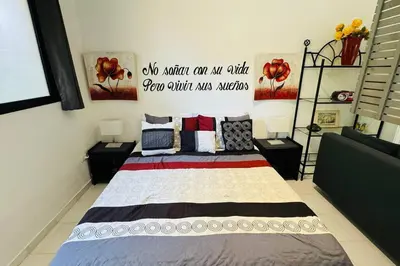 a bedroom with a bed with a sign on the wall at Residencial Tropimar Sosua in Sosúa