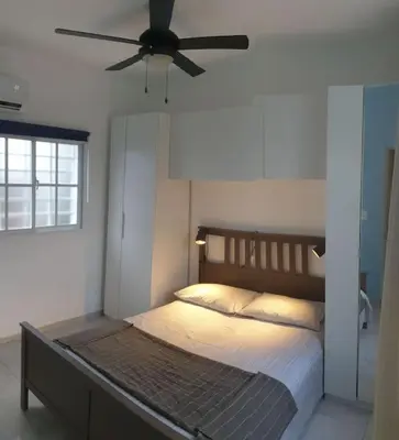 a bedroom with a bed with a ceiling fan at CasaMia RD B&B in Río San Juan