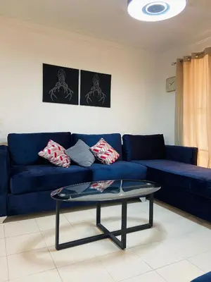 a living room with a blue couch and a coffee table at Cómodo y completo en el Cacique in Bella Vista