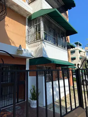 a building with a balcony with a green awning at Cómodo y completo en el Cacique in Bella Vista