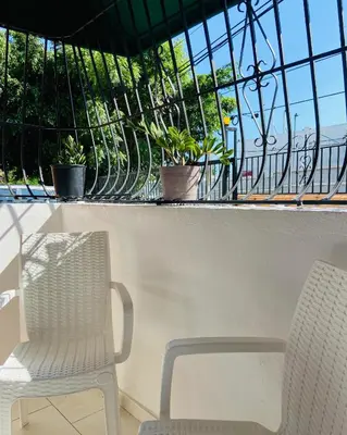 a white chair sitting on a balcony with plants at Cómodo y completo en el Cacique in Bella Vista