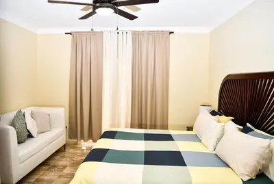 a bedroom with a bed and a couch at White Sands Punta Cana - Pool-Jacuzzi in Punta Cana