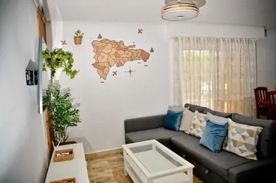 a living room with a couch and a map on the wall at White Sands Punta Cana - Pool-Jacuzzi in Punta Cana