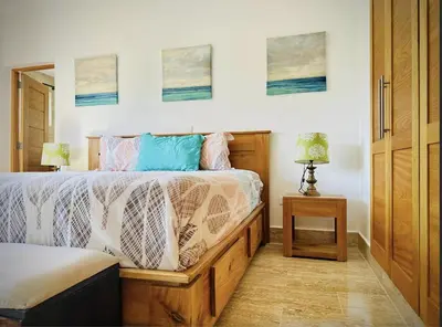 a bedroom with a bed and a table with a lamp at Departamento en las Terrenas a pie de Playa in Las Terrenas