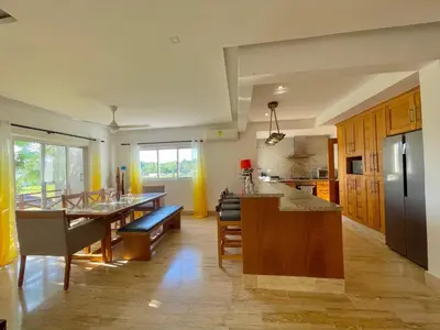 a large kitchen with a table and a counter at Departamento en las Terrenas a pie de Playa in Las Terrenas