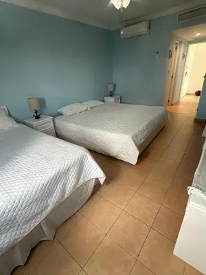 two beds in a room with blue walls at Paradise1 in Juan Dolio