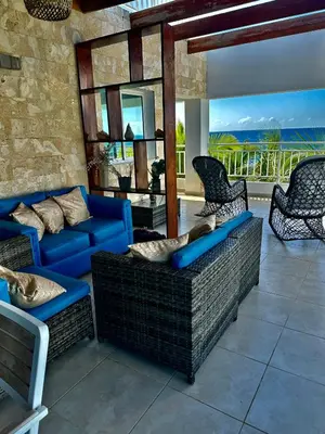 a living room with blue couches and chairs on a patio at Paradise1 in Juan Dolio