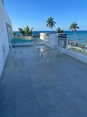a patio with a table and chairs on a balcony overlooking the ocean at Paradise1 in Juan Dolio