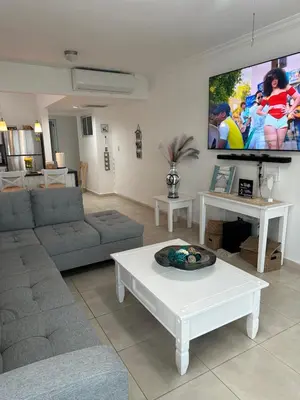 a living room with a couch and a tv on the wall at Paradise1 in Juan Dolio
