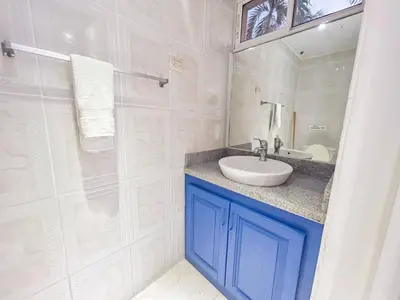 a white bathroom with a sink and a mirror at Garden Condos 43, Modern Condo In Sosa Center in Sosúa