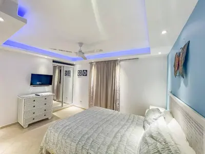 a bedroom with a white bed and a blue ceiling at Garden Condos 43, Modern Condo In Sosa Center in Sosúa