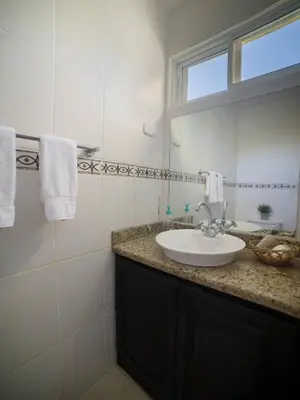 a white bathroom with a sink and a mirror at Garden Condos Apt 35 - Affordable 1br Apt In Sosua in Sosúa