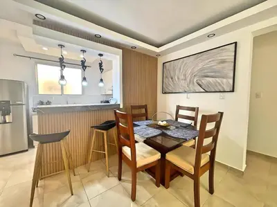 a dining room with a table and chairs and a kitchen at Apto 3 Habitaciones Zona Tranquila Con Parqueo in Concepción de La Vega