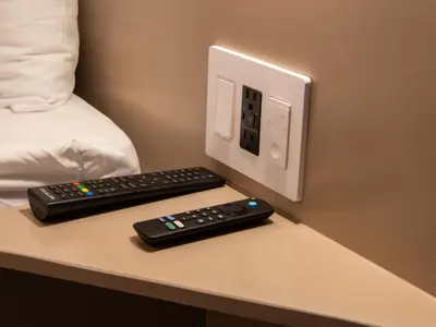 a computer monitor and two remote controls on a table at Garden Condos 39, Luxury Apartment In Sosua Town in Sosúa
