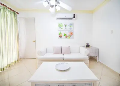 a living room with a white couch and a table at Garden Condos Apt 30 - Lovely 1br Condo W Pool in Sosúa