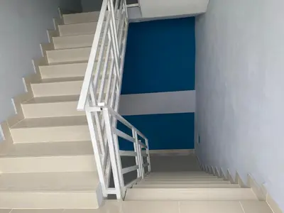 a stairway with a white rail and a blue wall at Mi lugar de descanso in Moca