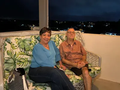 a man and woman sitting on a couch on a balcony at Mi lugar de descanso in Moca