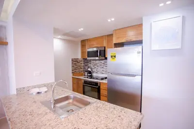 a kitchen with a sink and a stainless steel refrigerator at Xeliter Las Olas Juan Dolio in Guayacanes