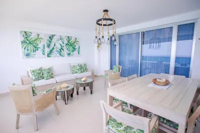 a living room with a table and chairs and a couch at Xeliter Las Olas Juan Dolio in Guayacanes