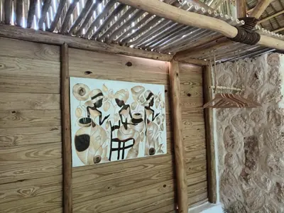 a room with a painting of hats on the wall at Samo Eco Lodge in Las Terrenas