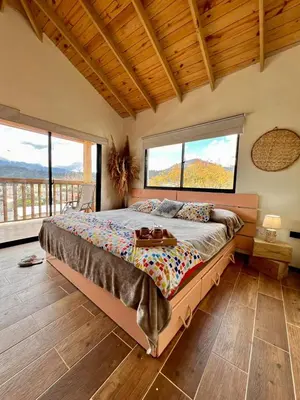 a bedroom with a large bed with two large windows at El ATiCO ConstanzaRD in Constanza