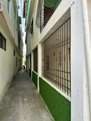 an empty alleyway between two buildings with green grass at El ATiCO ConstanzaRD in Constanza