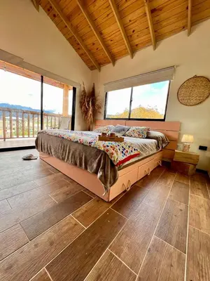 a bedroom with a large bed in a room with windows at El ATiCO ConstanzaRD in Constanza