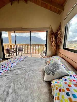 a bedroom with a large bed with a large window at El ATiCO ConstanzaRD in Constanza