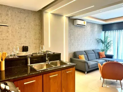 a kitchen with a sink and a couch in a room at Deluxe_Suite_1BDR_POOL_GYM_SAUNE in Santo Domingo