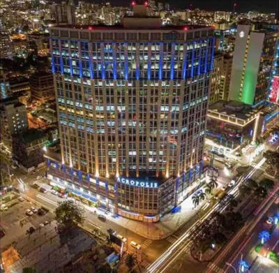 a tall building with blue lights on top of it at Deluxe_Suite_1BDR_POOL_GYM_SAUNE in Santo Domingo