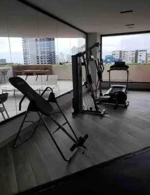 a gym with two exercise bikes in a room with windows at Deluxe_Suite_1BDR_POOL_GYM_SAUNE in Santo Domingo
