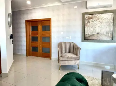 a living room with a chair and a painting on the wall at Suite Bolívar 3bdr - Pool - Cine -Saune - SPA- A8 in Santo Domingo
