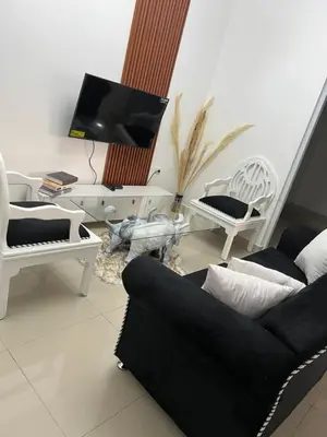 a living room with a couch and chairs and a tv at alojamiento en san juan de la maguana in SJM