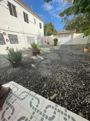 a gravel parking lot with plants in a yard at alojamiento en san juan de la maguana in SJM