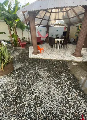 a patio with a table and chairs and an umbrella at alojamiento en san juan de la maguana in SJM