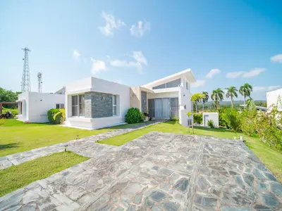 a villa with a large yard in front of a house at Amazing 2br Villa Near Surfing Beaches in Cabarete