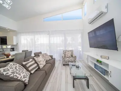 a living room with a couch and a flat screen tv at Amazing 2br Villa Near Surfing Beaches in Cabarete