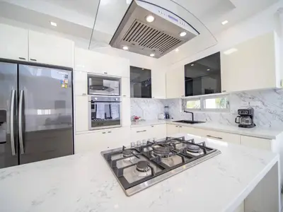 a white kitchen with a stove and a refrigerator at Amazing 2br Villa Near Surfing Beaches in Cabarete