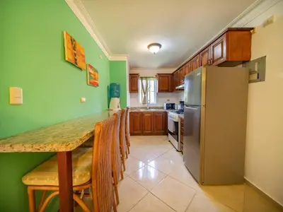 a kitchen with a table and a refrigerator at Garden Condos 40, 1br Apt In Sosua Strip Guest Ok in Sosúa