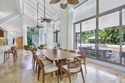 a dining room with a wooden table and chairs at Private Two-Storey Casa de Campo villa with pool, jacuzzi and golf cart in La Romana