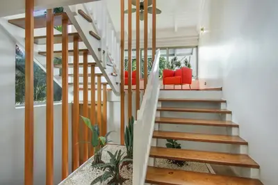 a staircase in a home with red chairs and a table at Private Two-Storey Casa de Campo villa with pool, jacuzzi and golf cart in La Romana