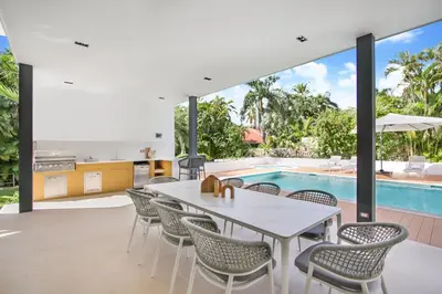 an open living room with a table and chairs and a swimming pool at Private Two-Storey Casa de Campo villa with pool, jacuzzi and golf cart in La Romana