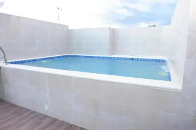 a large bath tub in a white tiled room at Hotel Dominican Barcelona in SJM