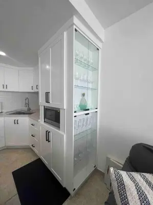 a kitchen with white cabinets and a microwave at Bueno Paradise Condo In Marbella in Juan Dolio