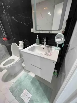 a bathroom with a toilet and a sink and a mirror at Bueno Paradise Condo In Marbella in Juan Dolio