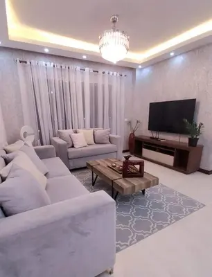 a living room with two couches and a television at Hermoso apartamento con vista al mar y la ciudad in La Romana