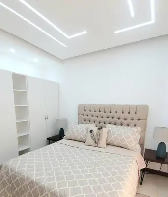 a bedroom with a large bed in a white room at Hermoso apartamento con vista al mar y la ciudad in La Romana