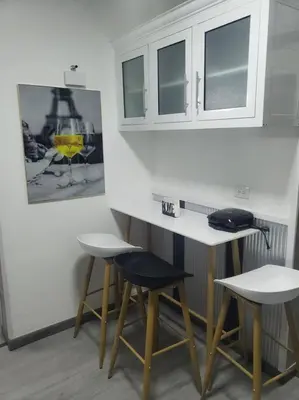 a kitchen with two bar stools and a white counter at Desiderio in Santo Domingo